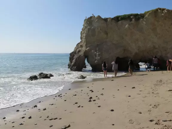 Incredible beach with blue-green water, rocks jutting out of the sea, arches, and caves.