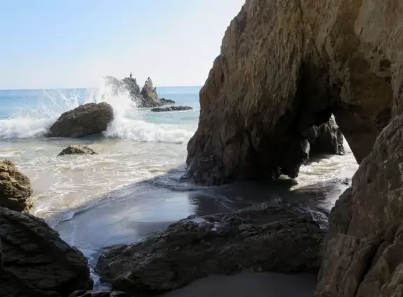 Incredible beach with blue-green water, rocks jutting out of the sea, arches, and caves.