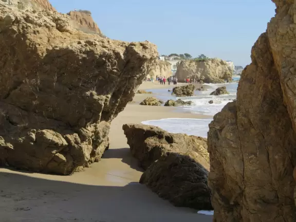 Incredible beach with blue-green water, rocks jutting out of the sea, arches, and caves.