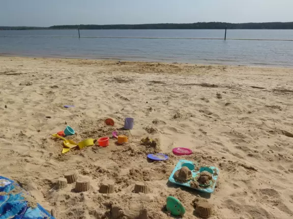Peaceful&nbsp;spot with nice sand (great for building), blue water (from a distance), the sound of water lapping the shore, green lawn, playground, and trees for shade.
