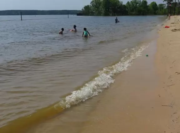 Peaceful&nbsp;spot with nice sand (great for building), blue water (from a distance), the sound of water lapping the shore, green lawn, playground, and trees for shade.