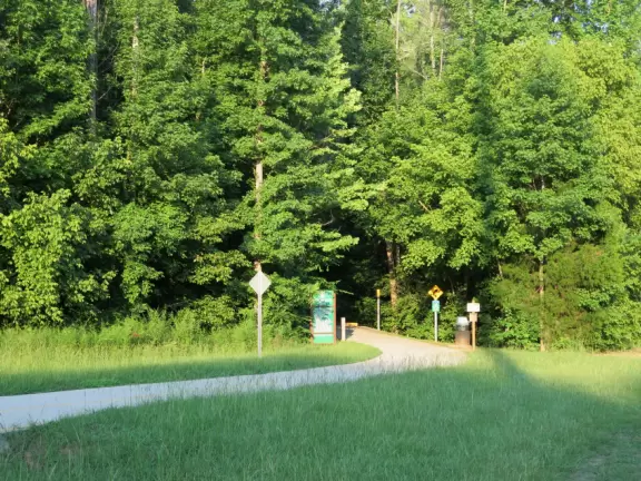<br />Paved greenway with tall trees that leads to Merritt's Pasture, a field. Stinky sewer in summer.