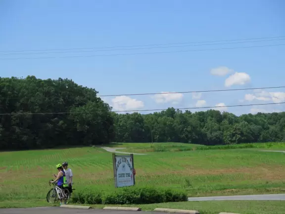 Wide patio with rocking chairs looking out on farmland.