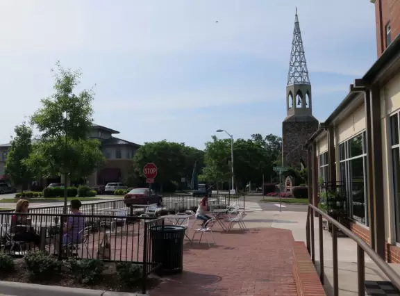 Cute area with outdoor cafes, flower boxes, church steeple with chimes, and village green&nbsp;where family events such as movie night or games night are held.