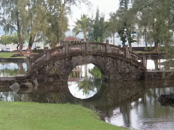Green, green&nbsp;gardens with Japanese bridges and ponds, and views of silvery Hilo Bay and Mauna Kea.