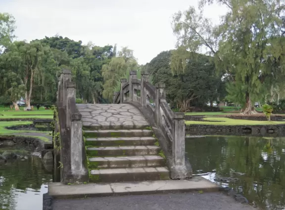 Green, green&nbsp;gardens with Japanese bridges and ponds, and views of silvery Hilo Bay and Mauna Kea.