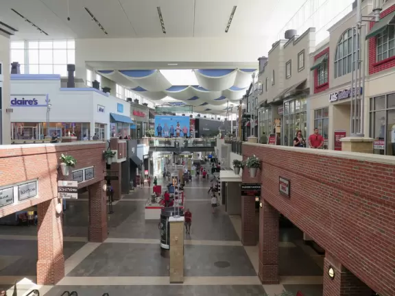 Upscale mall with indoor section like colorful streets and outdoor section with sidewalk cafes.