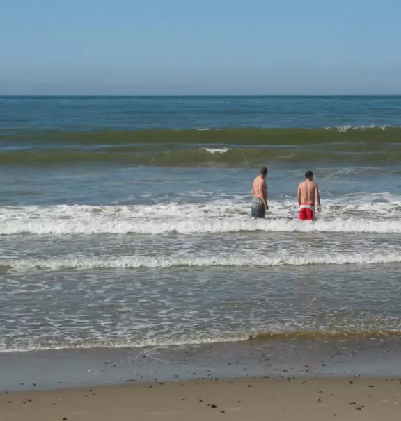 A strip of beachy shops and cafes, leading to a sandy beach.