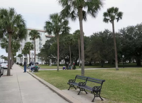 Park with some cabbage palms, statues, cannon balls, and&nbsp;promenade along the&nbsp;river.