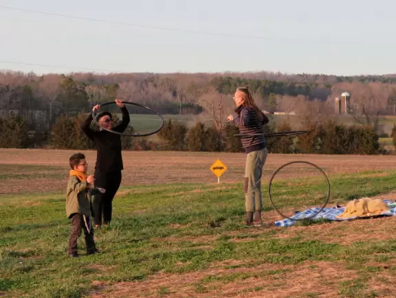 Wide patio with rocking chairs looking out on farmland.