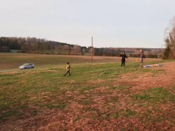 Wide patio with rocking chairs looking out on farmland.