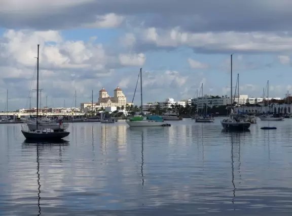 Wide walking path along the water with tropical flowers, piers, grand high rises, and palm trees- no shade though.