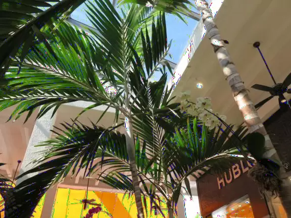 Ultra rich outdoor mall with gorgeous plants, fountains, sculptures, and flowers.