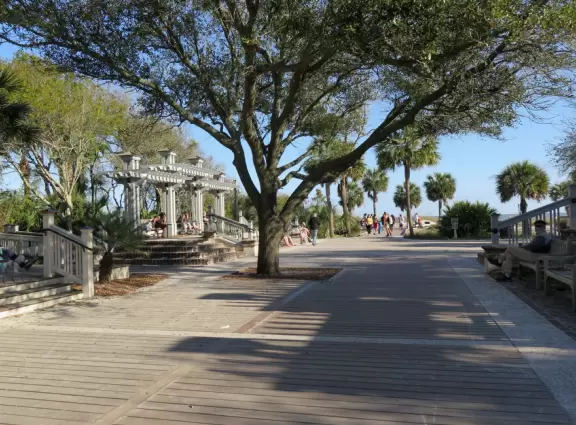 Wide white sand beach with lots of people enjoying the pleasant vibe. Bench swings and splash pad.
