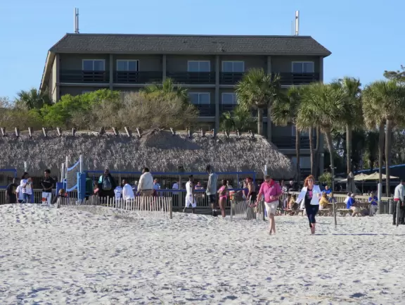 Wide white sand beach with lots of people enjoying the pleasant vibe. Bench swings and splash pad.