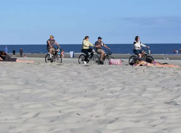 Wide white sand beach with lots of people enjoying the pleasant vibe. Bench swings and splash pad.