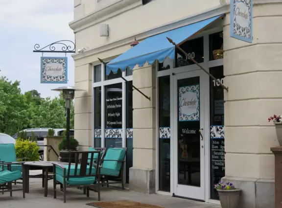 Stark French-style outdoor shopping center with large lawn for kids to play.