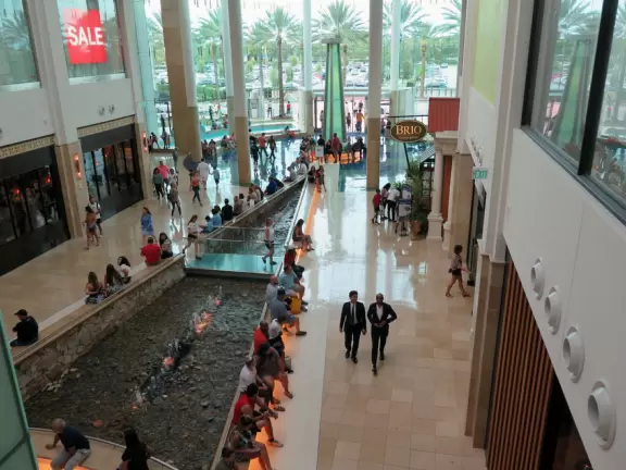 Impressive indoor mall with fountains and curved TV screens.