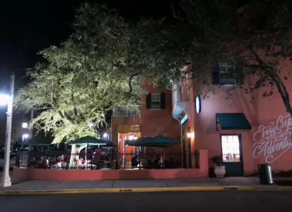 A popular town center with sidewalk cafes leading down to a pretty lake with a walking path.