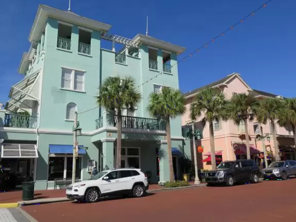 A popular town center with sidewalk cafes leading down to a pretty lake with a walking path.