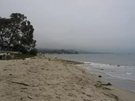 A walk under a canopy of tropical flowers to a beach fronted by luxury homes.