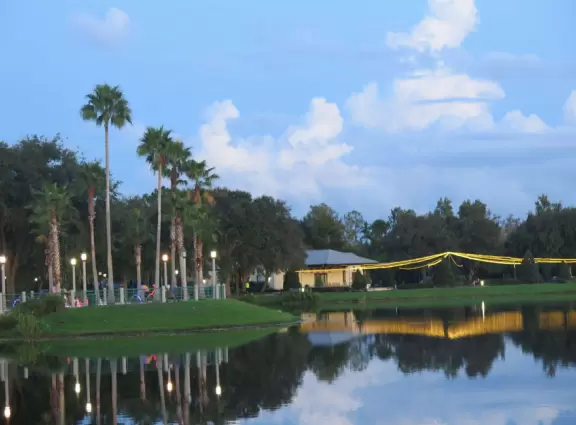 A popular town center with sidewalk cafes leading down to a pretty lake with a walking path.