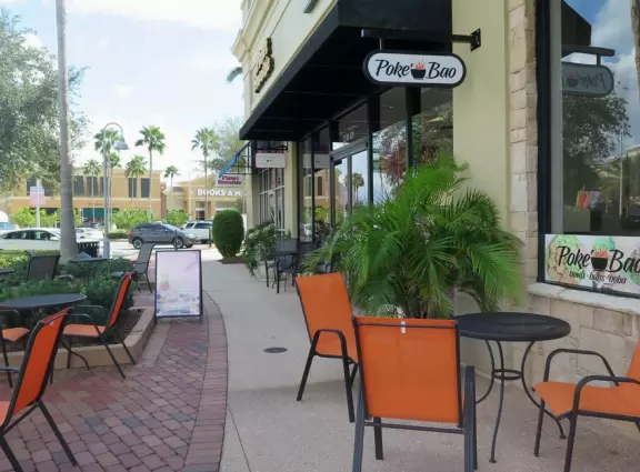 Spiffy outdoor mall with cute inner courtyard with strung lights, palms, and fountain.