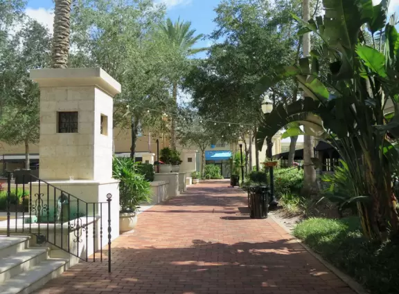 Spiffy outdoor mall with cute inner courtyard with strung lights, palms, and fountain.