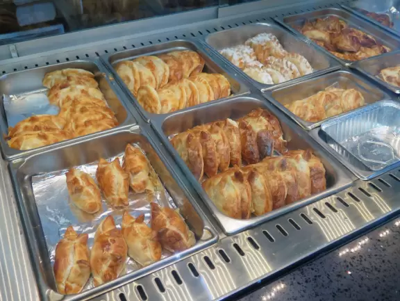 Picturesque beach with white lighthouse, happy people, and turquoise water.