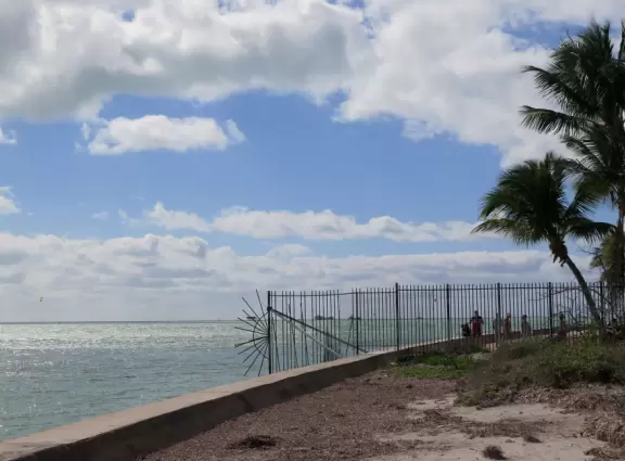 White lighthouse with blue-green water behind- a gorgeous sight! And easy to climb!