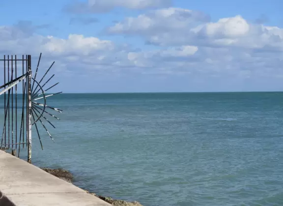 White lighthouse with blue-green water behind- a gorgeous sight! And easy to climb!