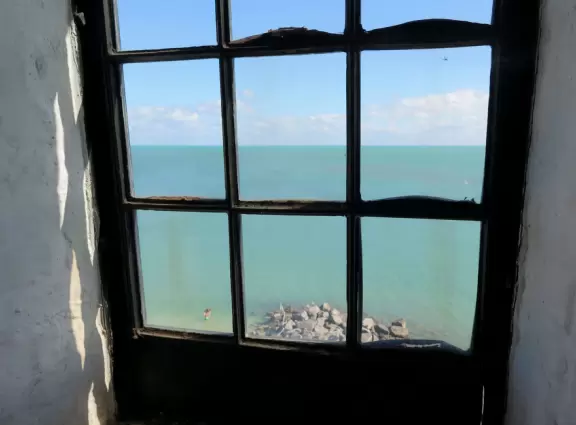 White lighthouse with blue-green water behind- a gorgeous sight! And easy to climb!