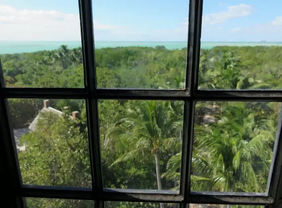 White lighthouse with blue-green water behind- a gorgeous sight! And easy to climb!