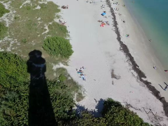 White lighthouse with blue-green water behind- a gorgeous sight! And easy to climb!