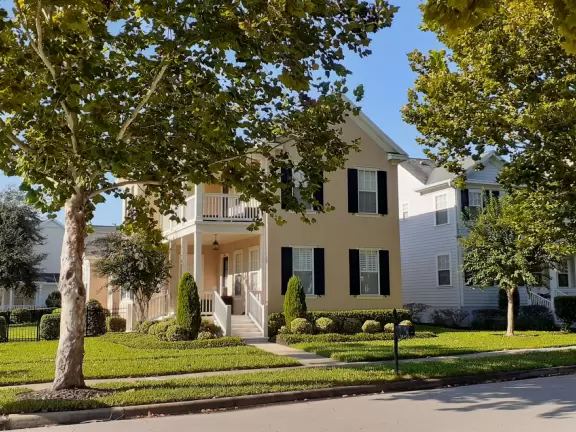 A popular town center with sidewalk cafes leading down to a pretty lake with a walking path.