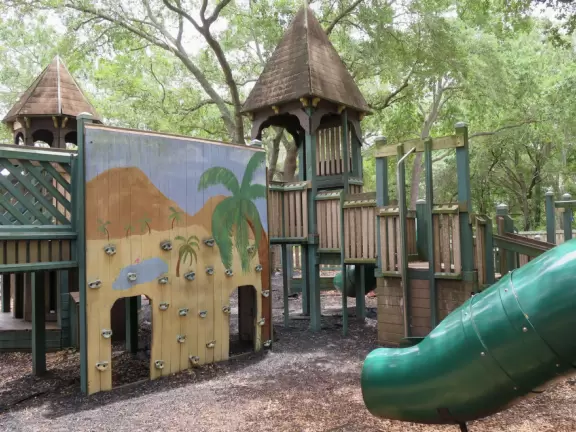 Beautiful park with wooden castle playground under wonderful trees.