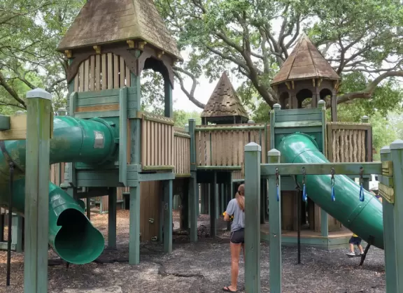Beautiful park with wooden castle playground under wonderful trees.