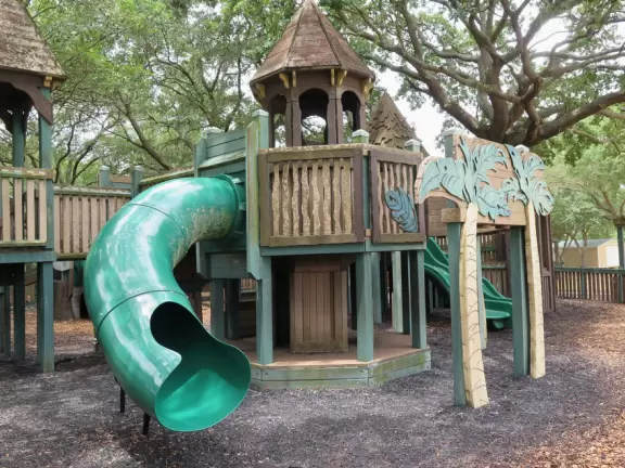 Beautiful park with wooden castle playground under wonderful trees.