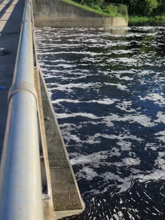 Popular park for biking and fishing, with a river and small dam.
