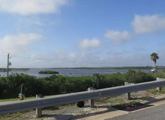 Fenced-off lighthouse with historical buildings.