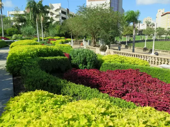 Beautiful garden with many partitioned areas, tropical plants, flowers, all with the blue lake behind. Plus, promenade around the lake.