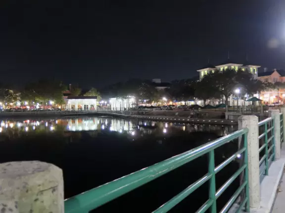 A popular town center with sidewalk cafes leading down to a pretty lake with a walking path.