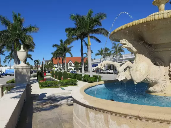 Lovely spot with long pool fountain, horse fountain, and European chairs under hedges.