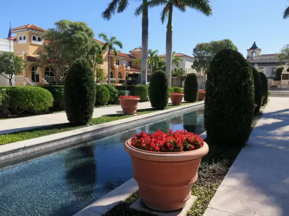 Lovely spot with long pool fountain, horse fountain, and European chairs under hedges.