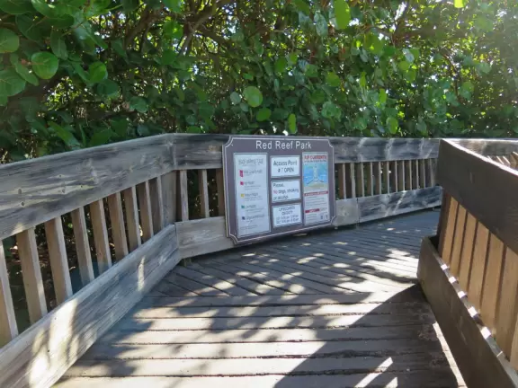 Beautiful narrow beach with lifeguard shack. Beach park has many coconut and banyan trees.