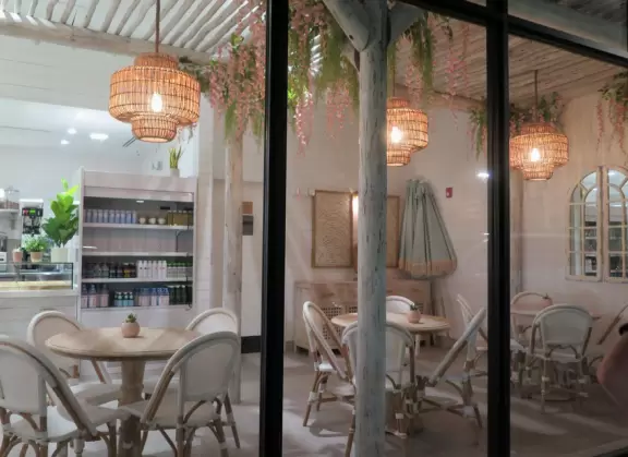 Outdoor shopping and entertainment district with European architecture, archways, palms, tropical flowers, and amazing fountain for kids.