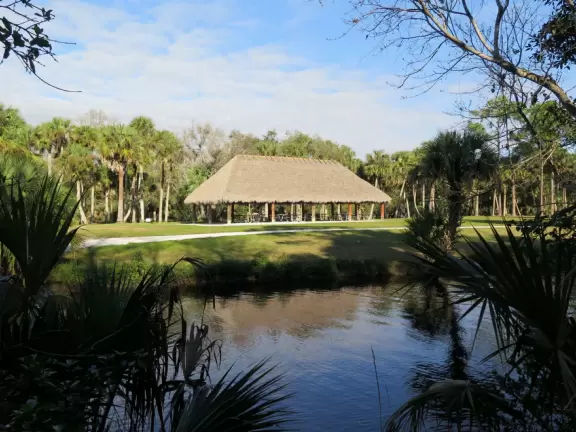 Tropical paradise with amazing trees, soft green grass, and woven huts shading picnic tables with BBQs that line the river, plus bike and kayak rentals. Beware alligators.