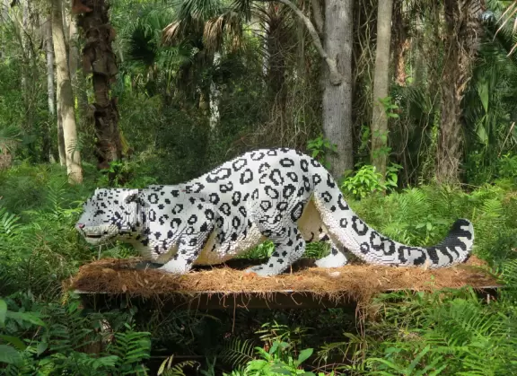 Lush paradise with water lilies galore, rustling bamboo, stone bridge, tropical flowers, strangler fig, and a gorgeous royal palm grove.