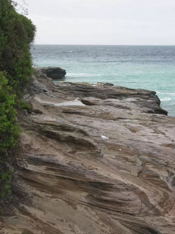 Sit on the rock ledge and watch the water swirl and spray below you!