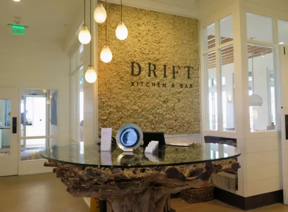 The entrance to Drift Kitchen with its teardrop lights and driftwood table.
